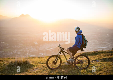 Mann auf Mountainbike Blick auf Blick auf den Sonnenuntergang, Salzburg, Österreich