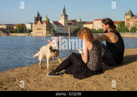 Menschen Sie genießen Sommer mit Hund Strelecky Insel Strand - Altstadt im Hintergrund, Prag, Tschechische Republik Stockfoto