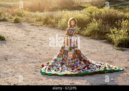 Mädchen, eingewickelt in eine Decke steht in einem Feld Stockfoto
