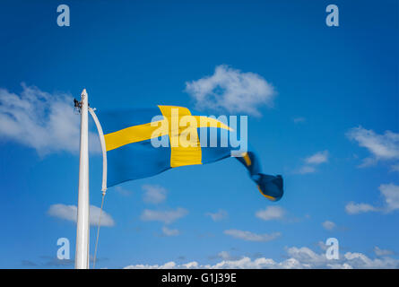 Bild einer Fahnenstange mit der Flagge von Schweden auf dem Hintergrund eines blauen Himmel fliegen. Stockfoto