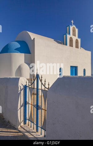 Bild einer weißen und blauen Santorin Kirche, in der scharfen Nachmittagssonne. Stockfoto