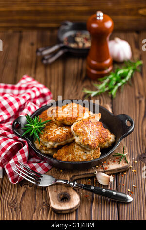 Fleisch Schnitzel in die Pfanne auf rustikalen Holztisch Stockfoto