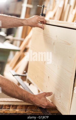 Details der Schreiner Hände mit Holzbrett Stockfoto