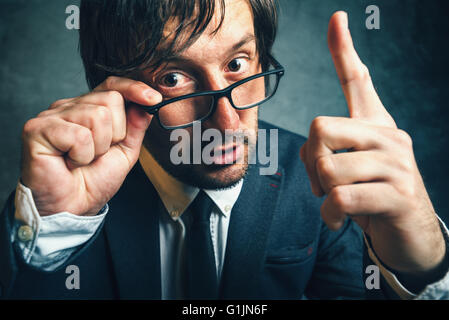 Wütend Steuerinspektor suchen ernsthafte und entschlossene, aggressive Finger drohen Erwachsenen Unternehmer mit Brille Stockfoto