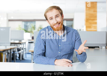 Lächelnd bärtigen Geschäftsmann am Tisch sitzen und reden Stockfoto