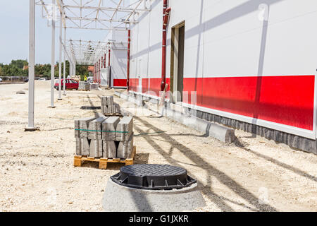 Kerb-Steinen auf Palette an Kies Boden Straßenbaustelle platziert. Stockfoto