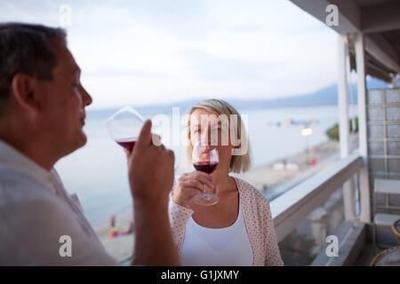 Paar, trinken Rotwein auf Balkon des Strandhotels Stockfoto