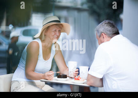 Ältere Frau Essen im Café mit ihrem Mann lächelnd Stockfoto