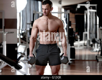 hübscher junger muskulöser Mann Übungen in einem Fitness-Studio Stockfoto
