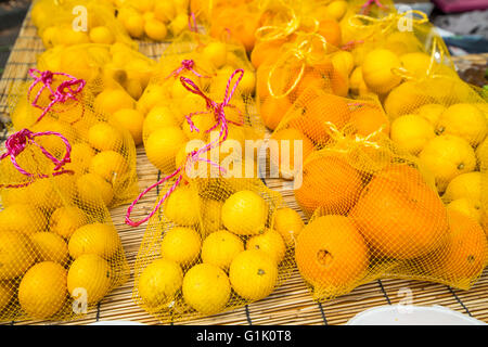 Orangen und Zitronen in Taschen am Markt Stockfoto