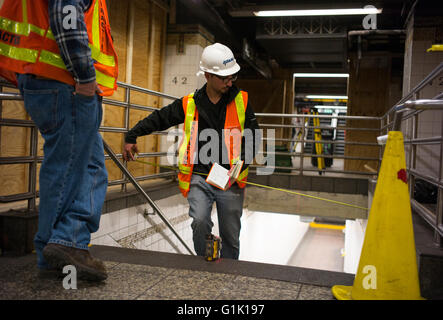 Ein Ingenieur misst ein Treppenhaus bei einer Reparatur an der New Yorker u-Bahn. Stockfoto