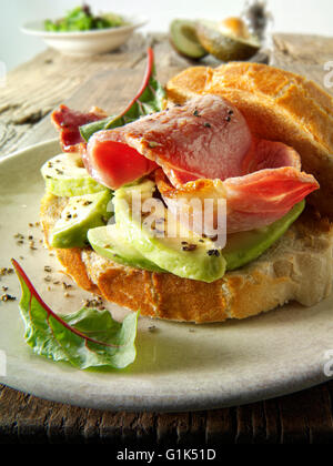 Vorbereitete Speck und Avocado Sandwich in Weißbrot auf einem Teller Stockfoto