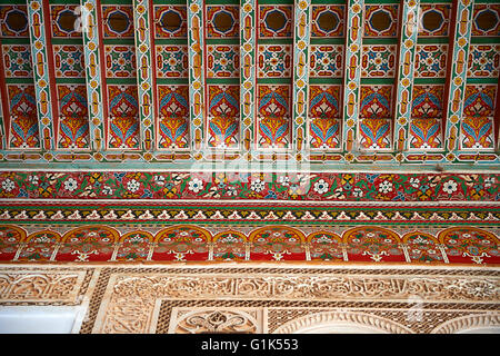 Berber Arabesken bemalte Holzdecke und Morcabe Platerwork Tür umgibt. Die Petite Gericht, Bahia-Palast, Marrakesch, Marokko Stockfoto