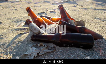 Verworfen, braunen Bierflaschen fangen Sonnenstrahlen während der verfallenden in der Wüste Stockfoto