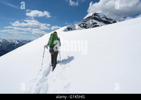 Weibliche Bergsteiger Wanderungen durch Schnee auf den Aufstieg zum Gipfel des Mount Schafreiter im Karwendelgebirge, Tirol, Österreich Stockfoto