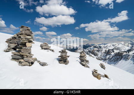 Cairns auf Mount Schafreiter mit dem Panorama der schneebedeckten Karwendelgebirge an einem sonnigen, klaren Tag im Frühling, Tirol, Österreich Stockfoto