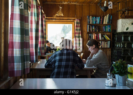 Wanderer am Tisch sitzen und entspannen in TheTölzer Hütte Speisesaal mit seinen alpinen Stil, Karwendelgebirge, Tirol, Österreich Stockfoto