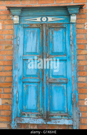 Alte Fenster mit geschlossenen Fensterläden aus Holz in einem alten ukrainischen Landhaus Stockfoto