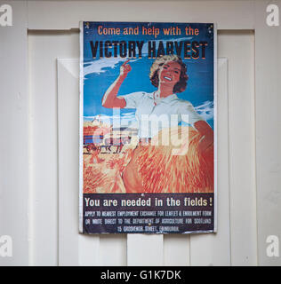 „You are Need in the Fields“: 2. Weltkrieg, 2. Weltkrieg, 2. Weltkrieg, 2. Weltkrieg; Schottisches Poster „Victory Harvest“, das Landmädchen an einer Tür im Dorf Haworth, Yorkshire, Großbritannien rekrutiert Stockfoto