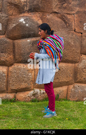 Mutter wartet auf ihr Kind durch eine Inka Wand in den Anden-Dorf Chinchero, Peru Stockfoto