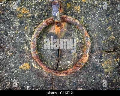 Rostige alte Gusseisen-Ring-set im gerissenen Beton. Stockfoto