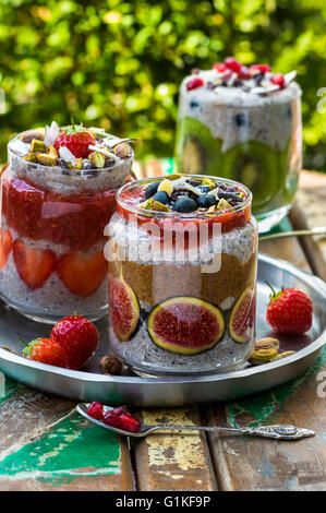 Chia Samen Pudding geschichtet, mit Früchten, Mandelbutter und Erdbeersauce Stockfoto