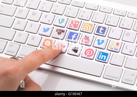 Bełchatów, Polen - 31. August 2014: Männliche Hand zeigen auf Schlüssel mit einer social-Media-Logo gedruckt und auf der Tastatur platziert. Stockfoto