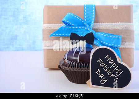 Happy Fathers Day Cupcake Geschenk auf blassen blauen und weißen Holz Hintergrund. Stockfoto