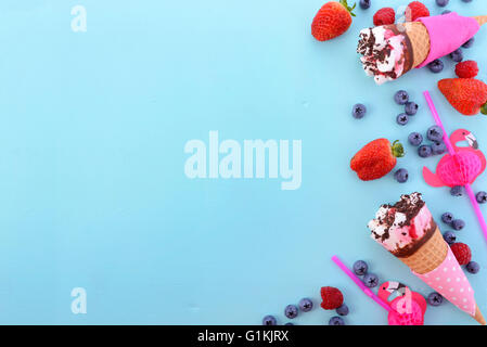 Rosa und blau Thema Sommer Hintergrund mit dekorierten Grenzen an Eis und Beeren auf Holz Hintergrund. Stockfoto