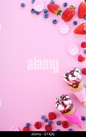 Rosa und blau Thema Sommer Hintergrund mit dekorierten Grenzen an Eis und Beeren auf Holz Hintergrund. Stockfoto
