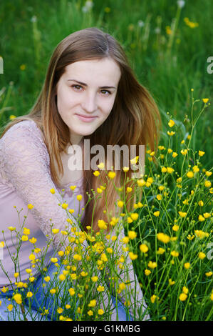junge Frau Blumenpflücken auf einer Sommerwiese Stockfoto