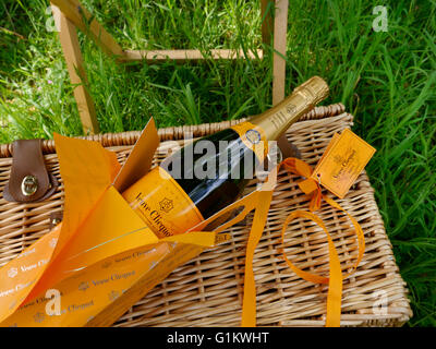 Flasche Veuve Clicquot Luxus Champagner & Präsentation Box auf alfresco Picknickkorb im grünen Sonnengarten Stockfoto