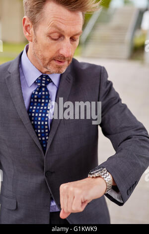 Mann sah auf seine Uhr, hetzen, um zu arbeiten Stockfoto