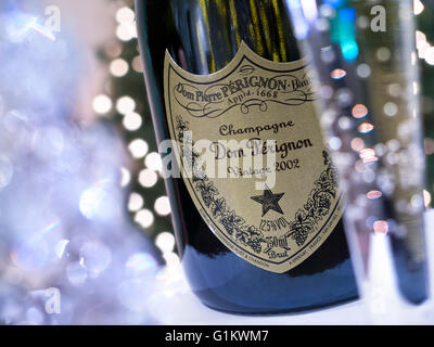 Flasche und frisch gezapftes Glas 2002 Dom Perignon Luxus-Jahrgangs-Champagner mit funkelnden Lichtern der Feier Stockfoto