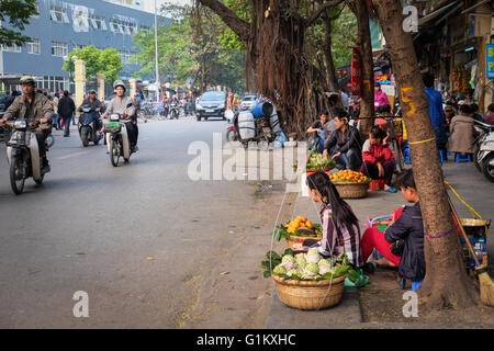 Leute verkaufen frisches Obst am Straßenrand außerhalb eines Krankenhauses in Hanoi Stockfoto