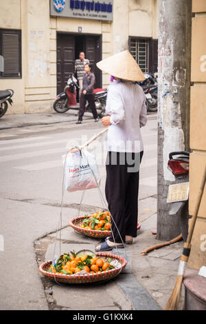 Eine Dame, die Mandarinen in Hanois Altstadt zu verkaufen Stockfoto