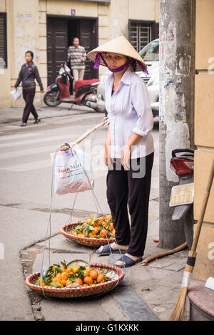 Eine Dame, die Mandarinen in Hanois Altstadt zu verkaufen Stockfoto