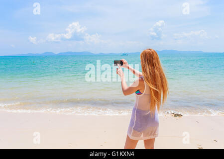 Glücklich attraktive Blondine im Bikini Fotografieren selbst an einem schönen sonnigen Strand Stockfoto