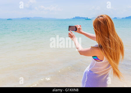 Glücklich attraktive Blondine im Bikini Fotografieren selbst an einem schönen sonnigen Strand Stockfoto