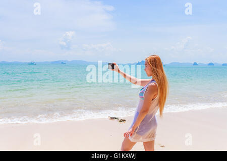 Glücklich attraktive Blondine im Bikini Fotografieren selbst an einem schönen sonnigen Strand Stockfoto