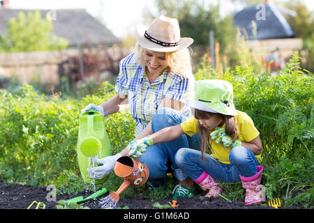 Mutter und Kleinkind Tochter Garten- und Bewässerung Stockfoto