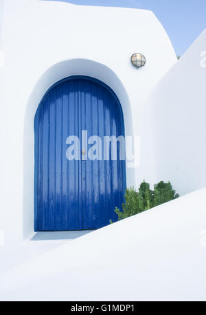 Blaue Tür und weiße Wand in einer Gasse der Insel Santorini - Griechenland Stockfoto