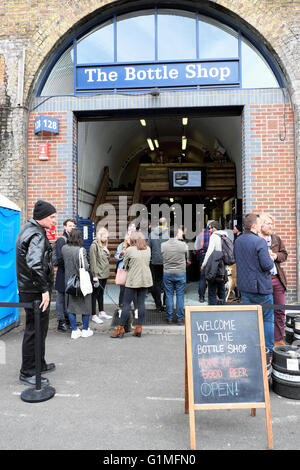 Menschen außerhalb Handwerk Bier outlet" die Flasche Shop" in Druid Street in der Nähe von maltby Ropewalk Bermondsey Street Market, London UK KATHY DEWITT Stockfoto