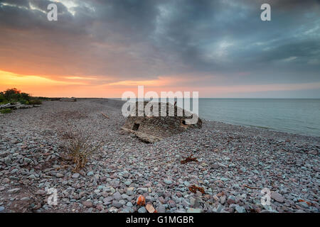 Dramatischen Sonnenuntergang über den Ruinen einer alten 2. Weltkrieg Bunker am Strand von Porlock Weir an der Exmoor Küste in Somerset Stockfoto