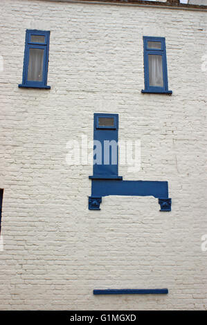 Weisses und blaues Haus, alte viktorianische Build mit blauen Fensterrahmen und blaue Tür mit lustigem Gesicht wie Fassade, in England Stockfoto