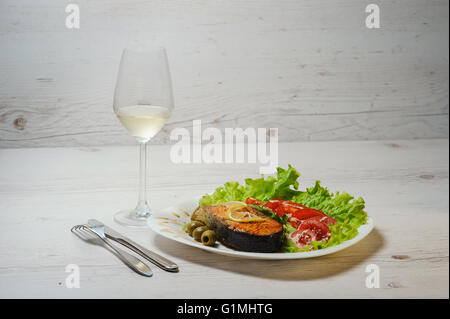 Gegrillter Lachs und Weißwein auf Holztisch. Stockfoto
