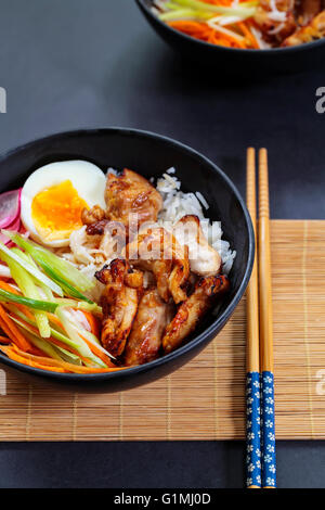 Gegrillte Hähnchenschenkel mit Reis und eingelegte Karotten, Zwiebeln und Radieschen Stockfoto