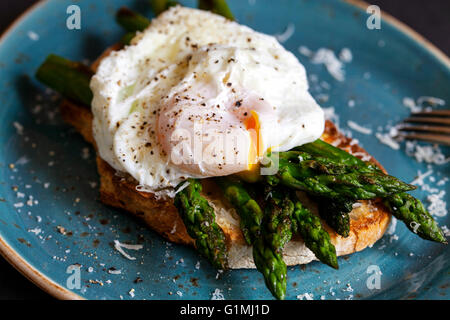 Geröstetes Sauerteigbrot mit gegrillter Spargel, pochiertem Ei und parmesan Stockfoto