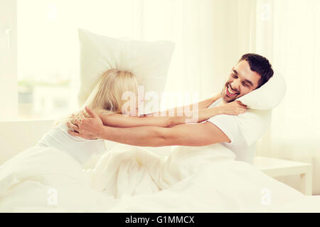 Brautpaar mit Kissen im Bett zu Hause zu kämpfen Stockfoto