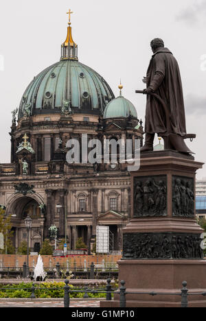 Statue eines Feuerwehrmannes in Berlin mit dem Berliner Dom im Hintergrund Stockfoto